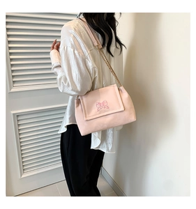 Shoulder bag with embroidered butterfly and chain strap shown on model's shoulder