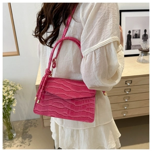 Detailed macro of bright pink crocodile pattern PU leather handbag with gold metal hardware