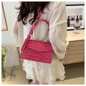 Detail of rose red crocodile embossed crossbody bag with smooth PU leather texture