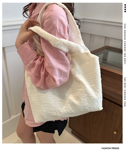 Detailed texture of white pleated tote bag showing soft three-dimensional fabric surface