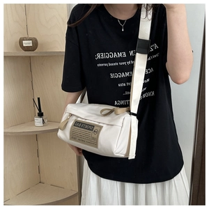 Gros plan d'un sac bandoulière en tissu oxford crème avec étiquette Sports Bag