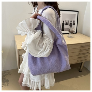 Detail of light purple tote bag featuring textured bubble fabric and wide shoulder strap