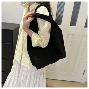 Detail showing the unique 3D bubble texture and quilted fabric of the large black tote bag