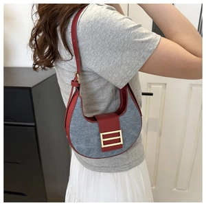 Detail of hobo underarm bag with grey suede fabric, red leather trim and golden buckle