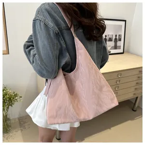 Détail du sac hobo plissé rose pâle montrant la texture et la grande capacité du modèle