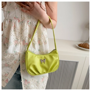 Détail du sac hobo vert fluo avec breloque papillon argentée et base à plis souples