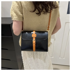 Détail du sac bandoulière vintage carré avec sangles contrastées porté par un mannequin