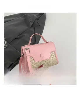 Detail of pink PU leather and straw woven bag with circular buckle and adjustable strap