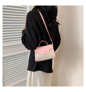 Close-up of pink leather trim and beige woven straw texture on a mini summer handbag