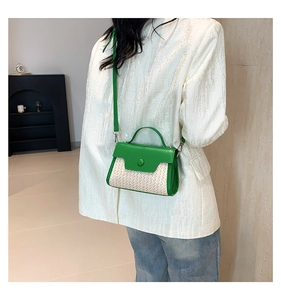Detail of green PU leather and woven rattan small square bag styled with a white blazer
