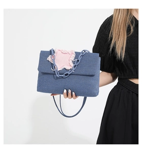 Blue denim crossbody bag featuring a pink frayed star patch and chunky blue plastic chain