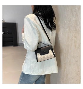 Detail of minimalist contrast color crossbody bag with textured fabric and leather strap