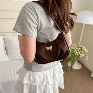 Sac sous le bras plissé marron foncé chic avec boucle papillon argentée sur mannequin