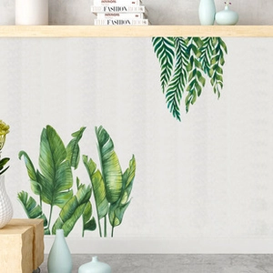 Detail of watercolor green plant wall decals on a textured grey wall in a Nordic room