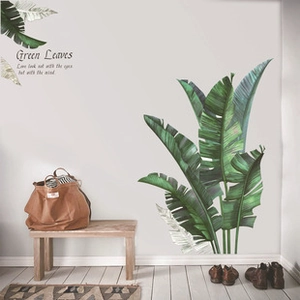 Close-up of green banana leaf wall stickers in a minimalist living room interior