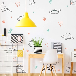 Nursery wall decals featuring cartoon dinosaurs and leaves in a bright study corner decor