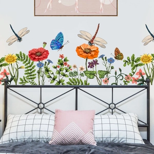 Poppy and daisy floral wall decals with butterflies above a black metal bed frame