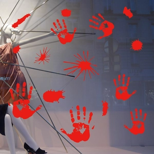 Macro shot of red bloody handprint and splatter static stickers on glass shop window