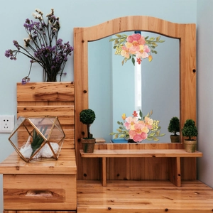 Floral mirror decals with pink and orange flowers on a vanity table mirror
