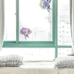 Realistic hydrangea wall sticker with purple ribbons applied on a clean window glass