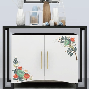 Detailed view of floral wall decals applied on a white cabinet with gold handles