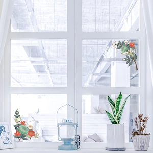 Detail of floral window decals with green leaves and orange flowers on bright glass
