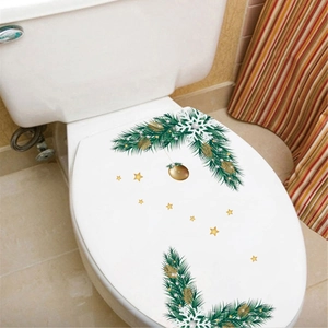 Detail of Christmas toilet lid stickers with green pine branches and gold ornaments
