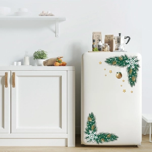 Christmas fridge stickers with pine branches, snowflakes, and gold stars on white fridge