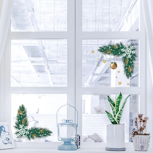 Christmas window decals with snowflakes and golden ornaments on a white framed glass pane
