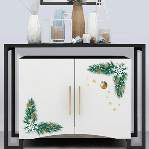 Detailed Christmas corner stickers with pine branches and gold ornaments on white cabinet