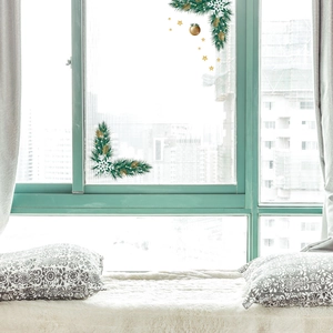 Close-up of Christmas window stickers with pine branches, snowflakes and golden ornaments