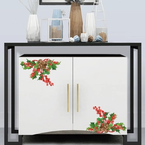 Detail view of Christmas holly leaf and berry stickers on white cabinet surface