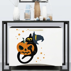Close-up of Halloween cat and pumpkin lantern decals on a modern white storage cabinet