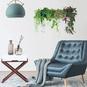Detail view of a light wood wall shelf styled with hanging green plants in a cozy room
