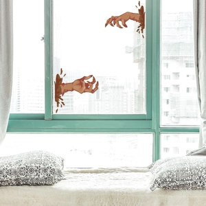 Scary monster hand window decals for Halloween decorations on a modern glass window