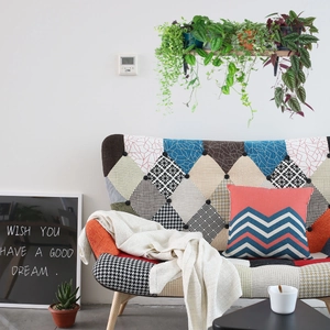 Bohemian patchwork fabric sofa with button tufting and solid wood legs in a bright living room