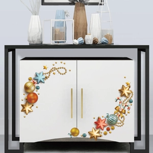 Macro detail of 3D Christmas stickers with golden stars and colorful ornaments on white cabinet