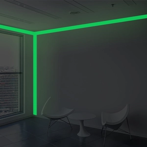 Luminous green photoluminescent tape applied to dark indoor stairs for night safety