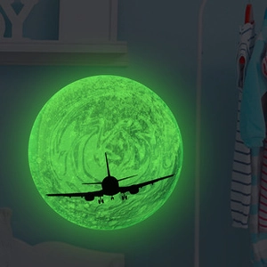 Détail d'autocollant mural lune lumineuse avec silhouette d'avion pour chambre