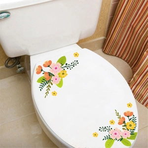 Detail of floral self-adhesive PVC stickers with orange and pink flowers on a white toilet lid