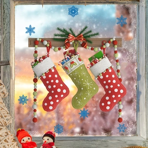 Trois chaussettes de Noël tricotées avec cadeaux suspendues à une tringle en bois