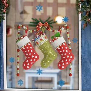 Détail de trois chaussettes de Noël à pois et flocons sur des crochets en bois