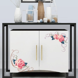 Detail of pink floral rose corner stickers applied to a white minimalist cabinet door