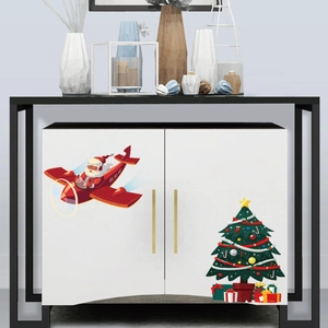Christmas wall stickers with Santa in a red plane and a decorated tree on a white cabinet