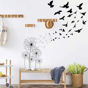 Detail of minimalist black dandelion and flying bird wall stickers in a modern bedroom