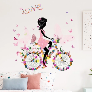 Détail du stickers mural fille à vélo fleuri avec papillons pour décoration de chambre