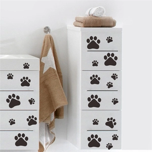 Black paw print wall decals for home decor applied on a white minimalist drawer
