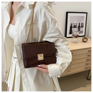 Détail du sac bandoulière marron foncé à motif crocodile avec fermoir carré doré