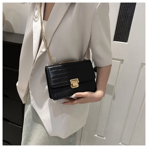 Gros plan du sac carré noir motif crocodile avec fermoir doré et bandoulière chaîne
