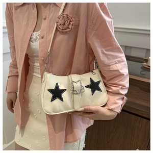Close-up of the Y2K style white underarm bag with black star patches and metal star buckle